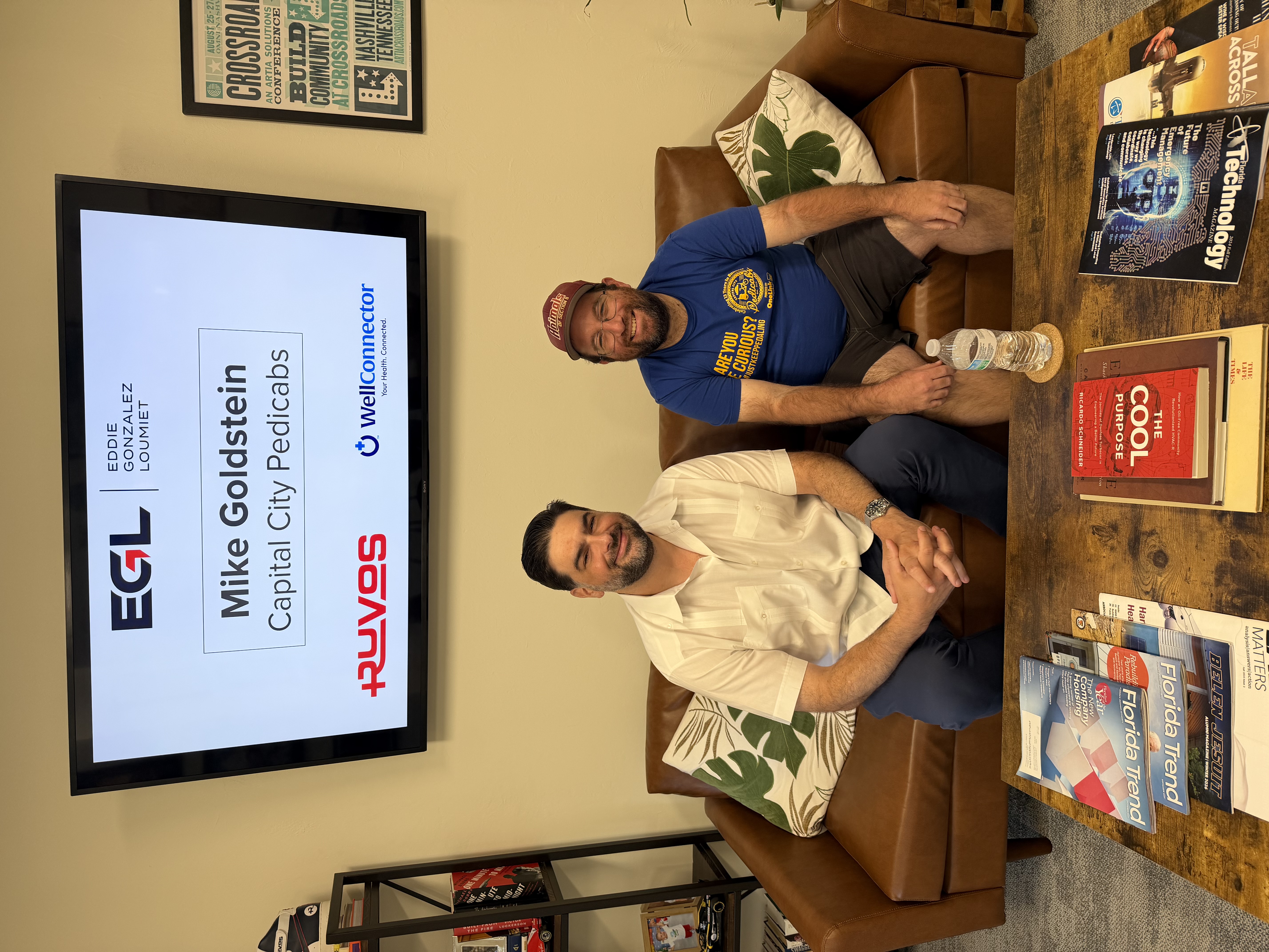 Eddie Gonzalez Loumiet sitting with a visitor on the couch in his office