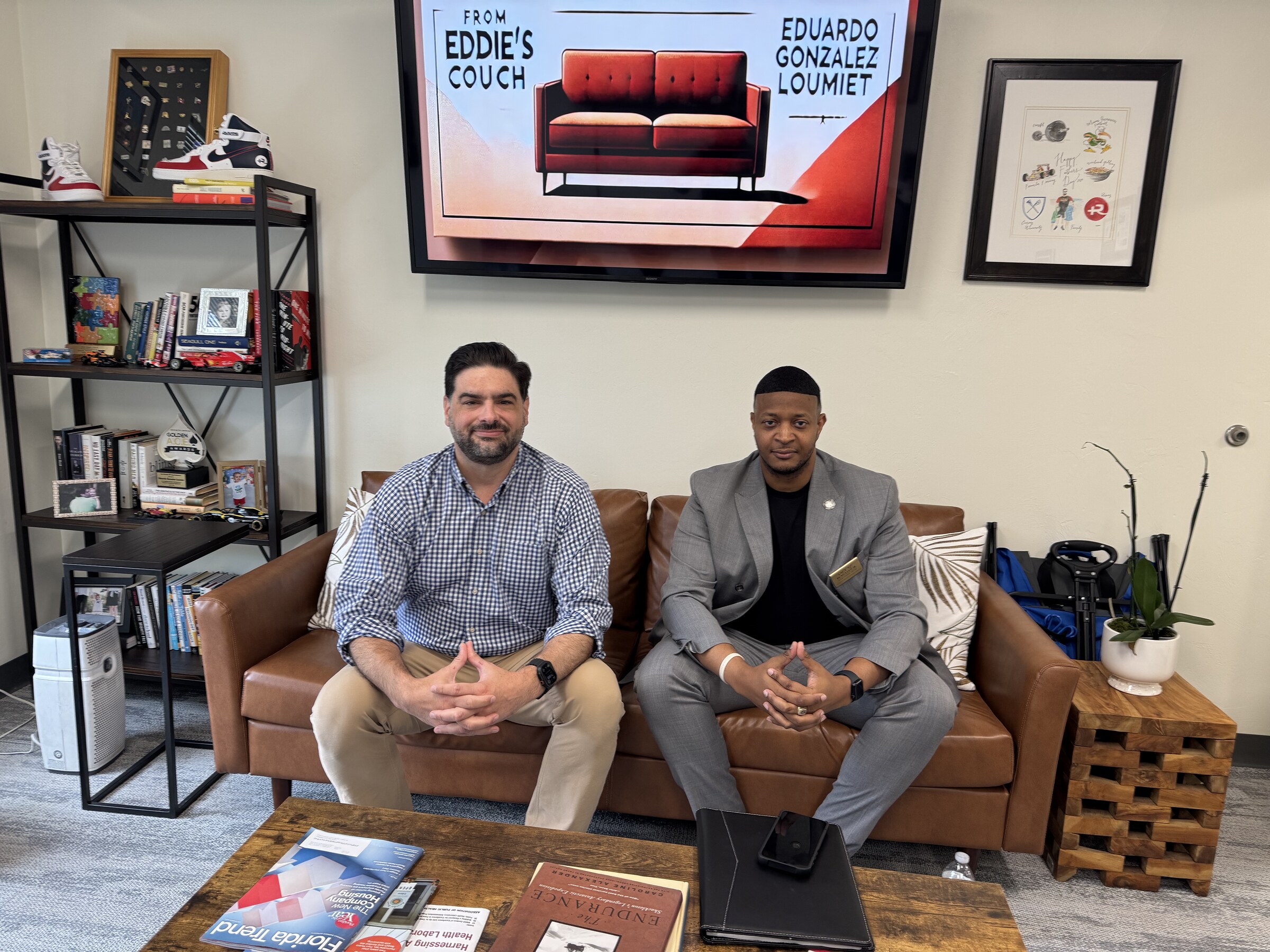 Eddie Gonzalez Loumiet sitting with a visitor on the couch in his office