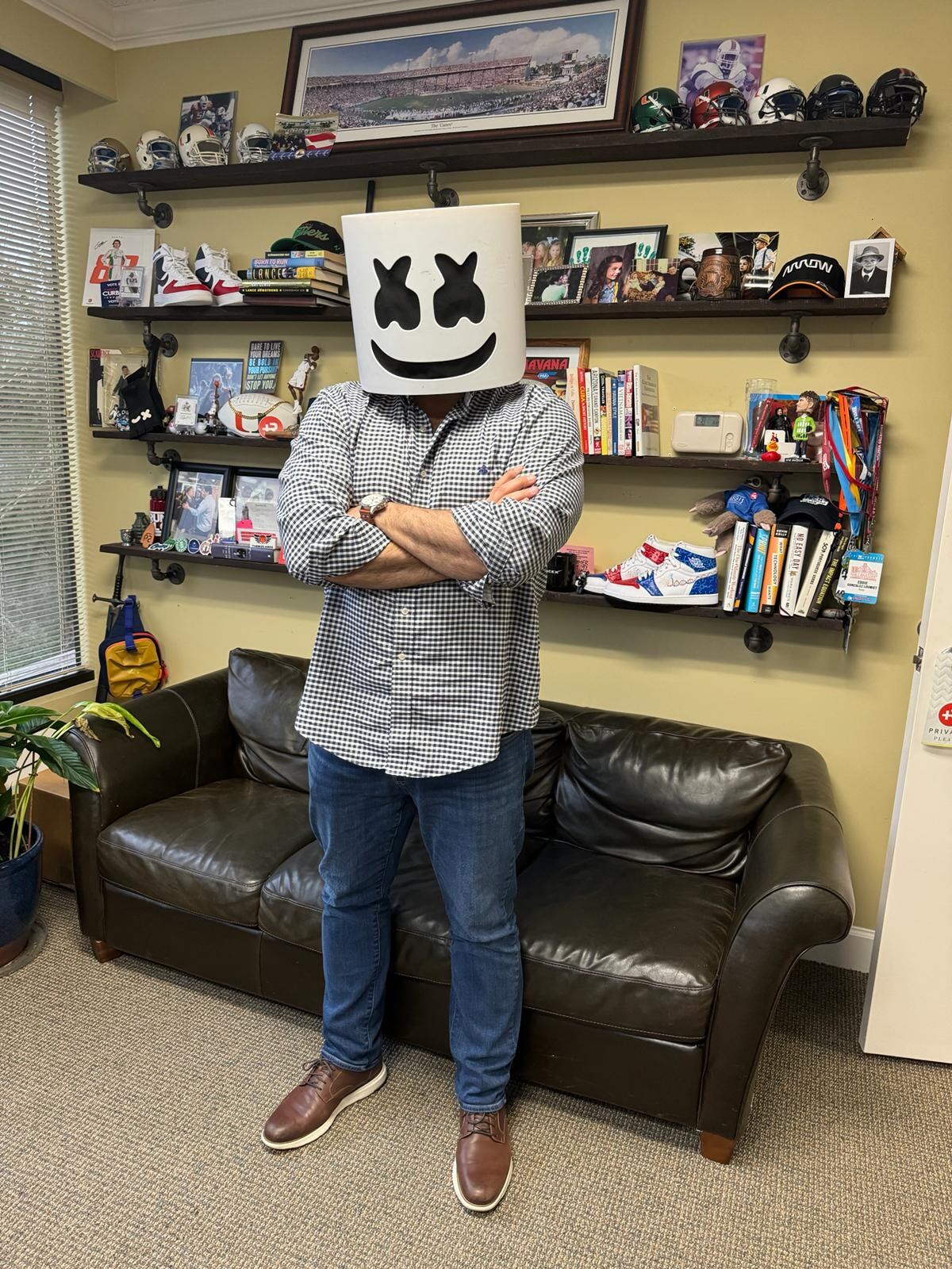 A visitor standing in front of the couch in Eddie Gonzalez Loumiet's office