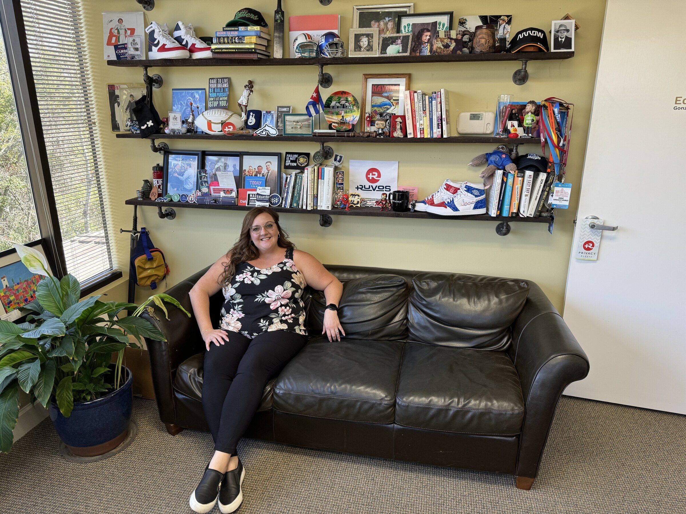 A visitor sitting on the couch in Eddie Gonzalez Loumiet's office