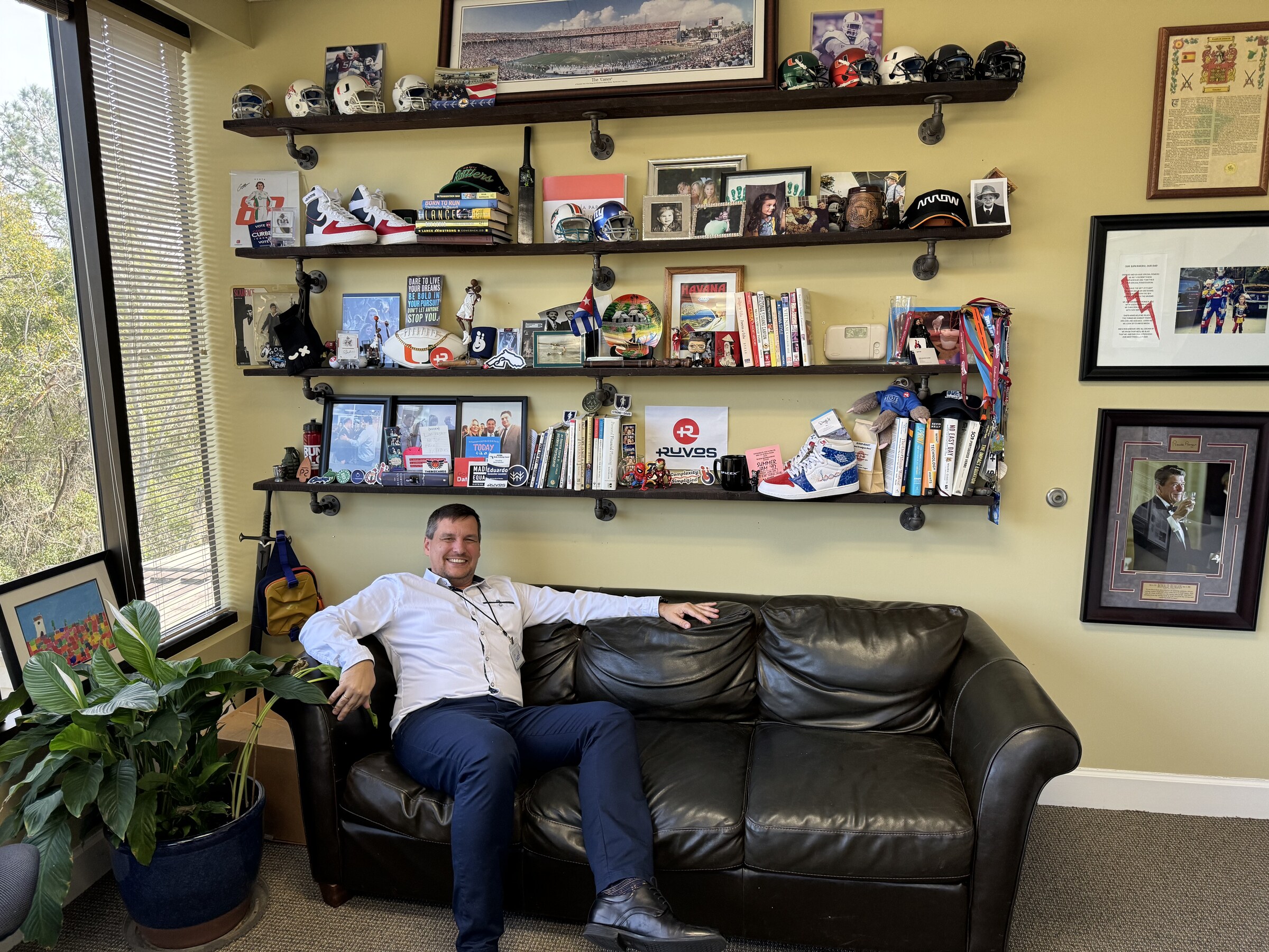 A visitor sitting on the couch in Eddie Gonzalez Loumiet's office