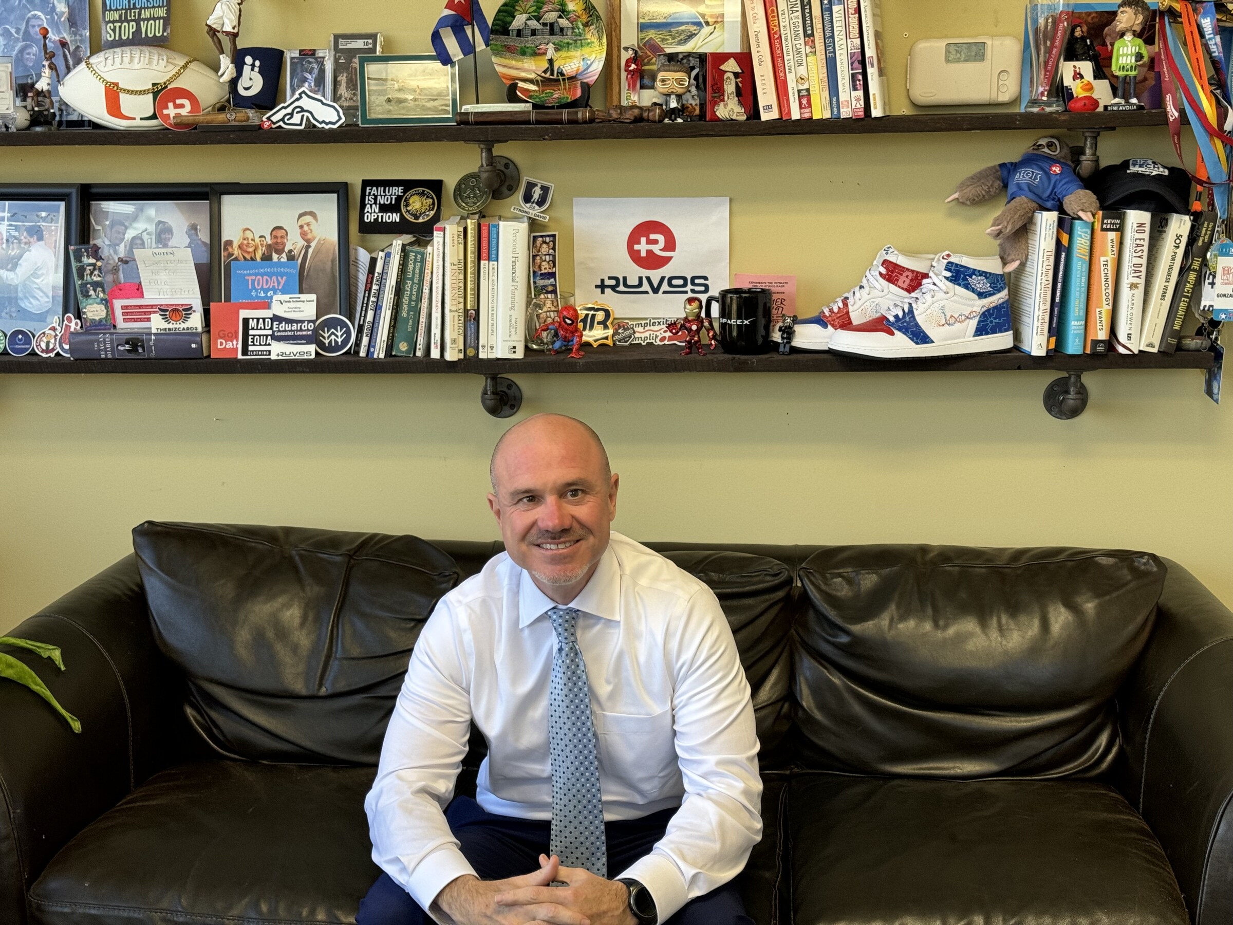 A visitor sitting on the couch in Eddie Gonzalez Loumiet's office